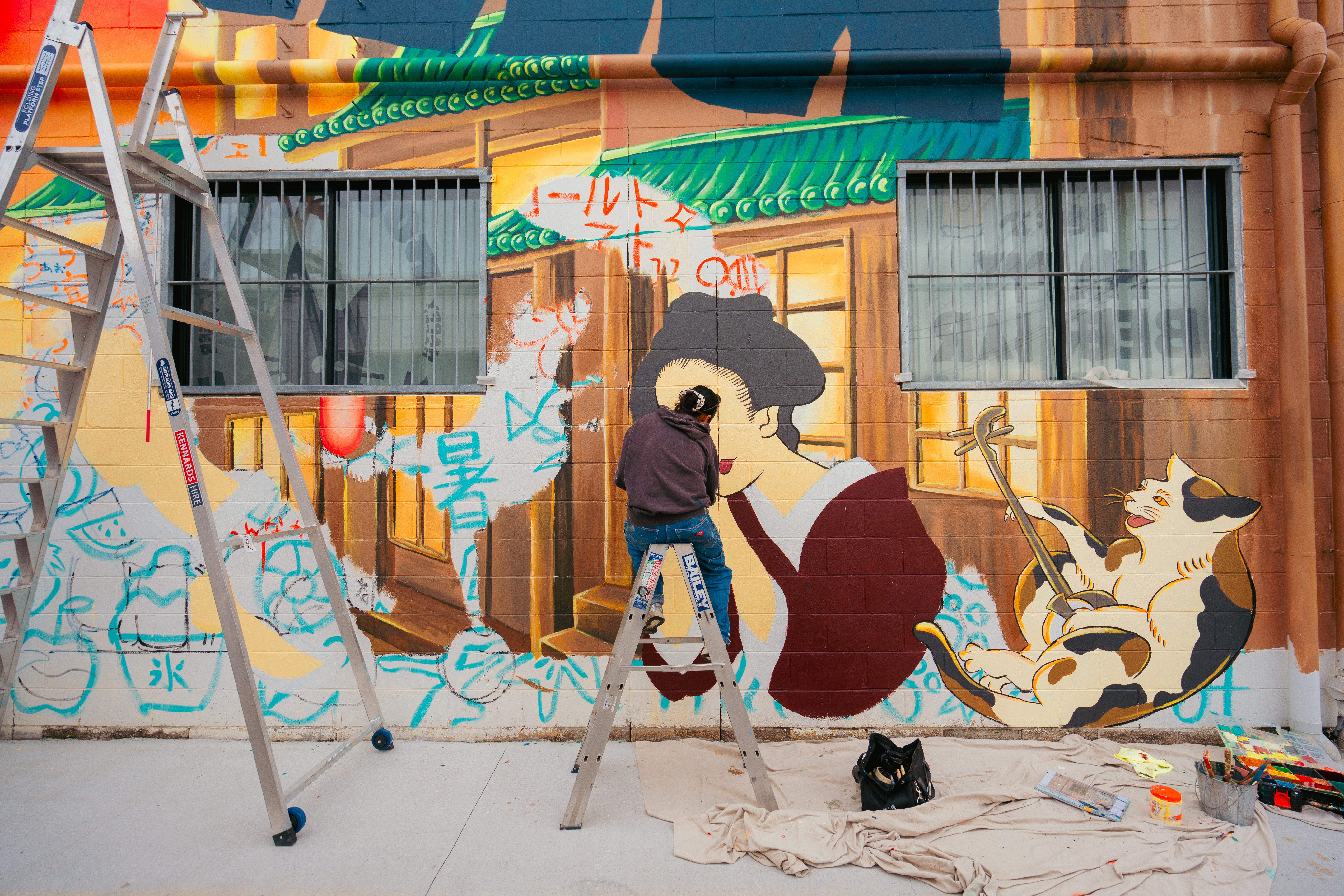 Muralist Kaho Michishita live painting her mural at Roji Cat on Lemana Lane