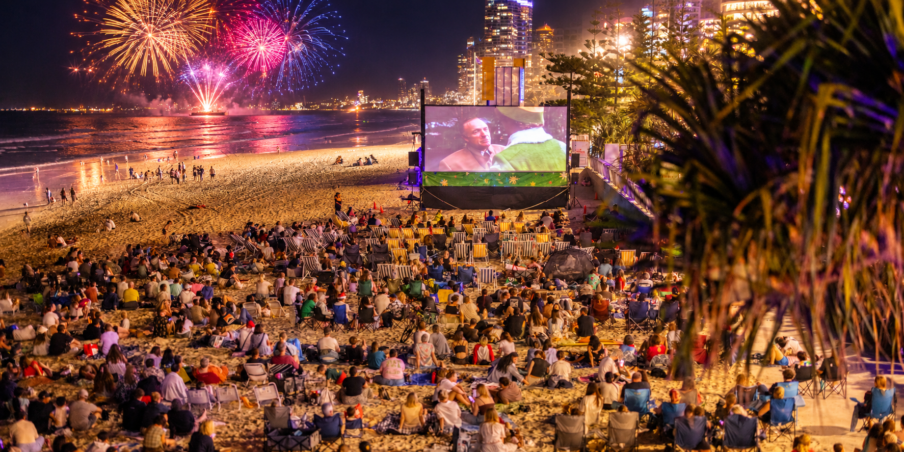 Outdoor cinema on the beach, fireworks in the background